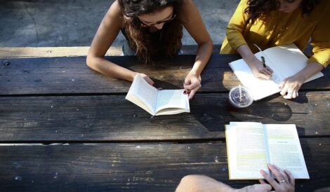 Schüler an einem Tisch aus Holz, draußen in der Natur bereiten sich für den Englisch A1 Test vor